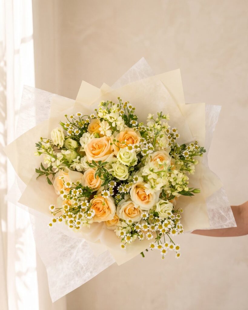 Peach Tea: peach and cream roses, white stock and feverfew, hand-tied and wrapped in ivory paper by Valley Bloom Shop, Athens TN